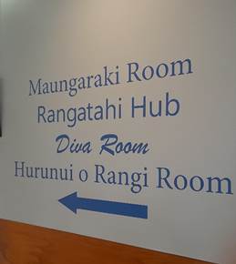 A white wall with blue writing

Description automatically generated
