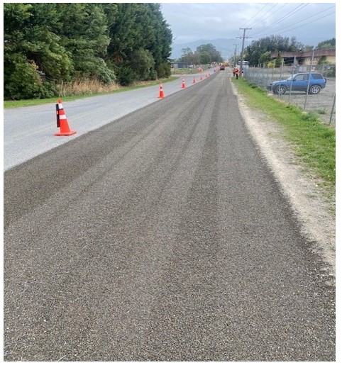 A road with orange cones and a fence

Description automatically generated