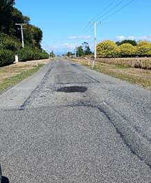 A road with a pothole on it

Description automatically generated