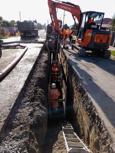 A construction workers working on a road

Description automatically generated