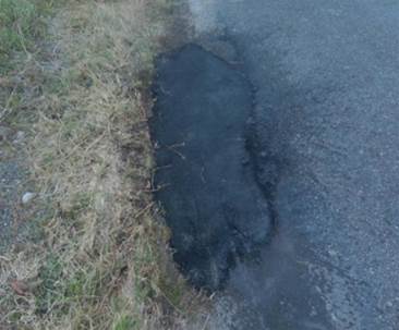 A pothole on the side of a road

Description automatically generated