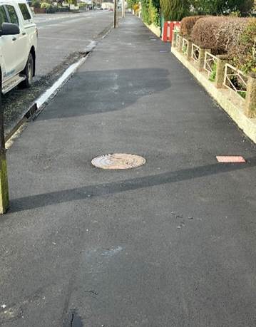 A road with a manhole cover

Description automatically generated