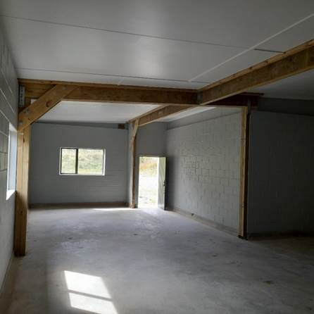 A room with a window and concrete walls

AI-generated content may be incorrect.