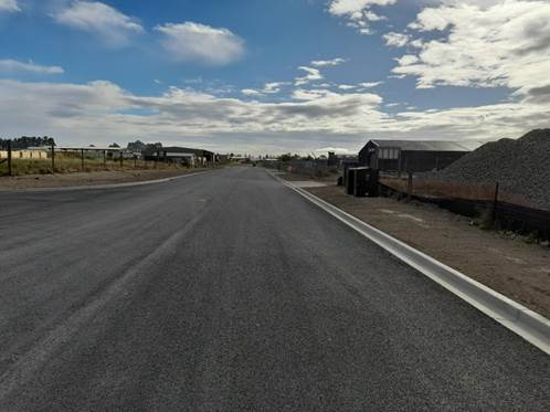 A road with buildings and a blue sky

AI-generated content may be incorrect.