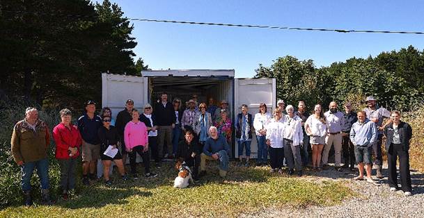 A group of people standing in front of a white container

AI-generated content may be incorrect.