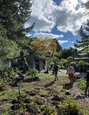 A group of people walking in a dirt path with trees and a building

AI-generated content may be incorrect.