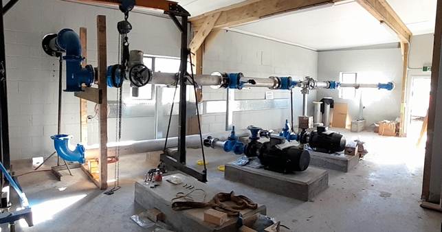 A room with several pipes and a crane

AI-generated content may be incorrect.