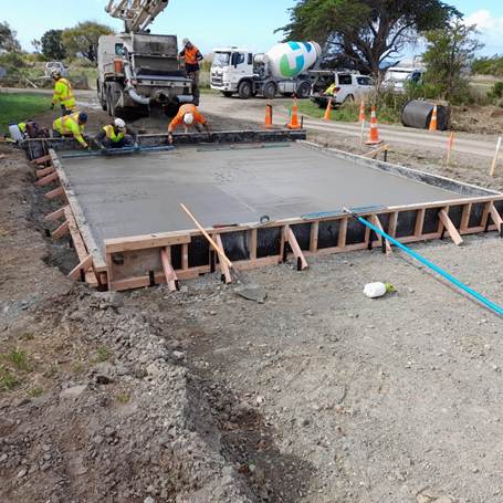 A construction site with workers working on a concrete slab

AI-generated content may be incorrect.