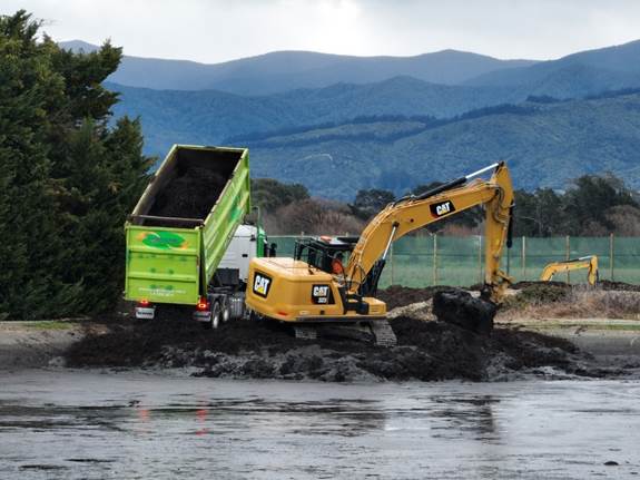 A yellow excavator loading a dump truck
AI-generated content may be incorrect.